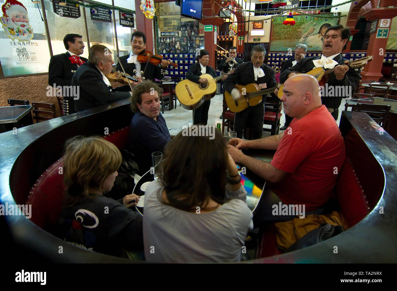 Città del Messico - 2019: Mariachi eseguire per una famiglia presso un bar tradizionale in Piazza Garibaldi (piazza Garibaldi) su una domenica notte. Foto Stock