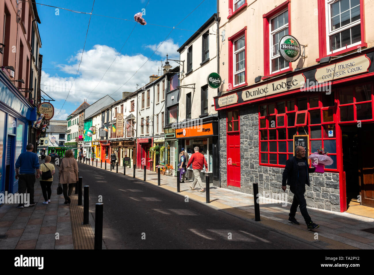 Killarney Town. Colorati negozi bar ristoranti e turisti nella stretta Plunkett Street nel centro della cittadina di Killarney in Irlanda Foto Stock