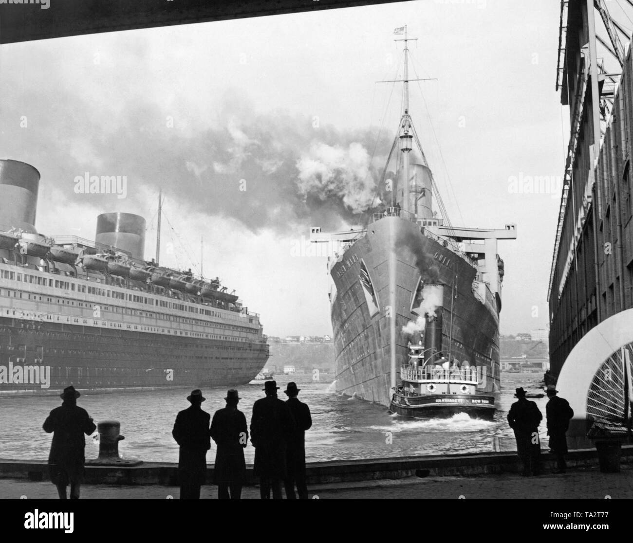 La regina Maria' Lascia New York. Come un vettore di truppa, il British luxury liner navigato a Città del Capo e Sidney per espandere il fronte del Pacifico. Sul lato sinistro della banchina giace il francese ocean liner "Normandie". Foto Stock