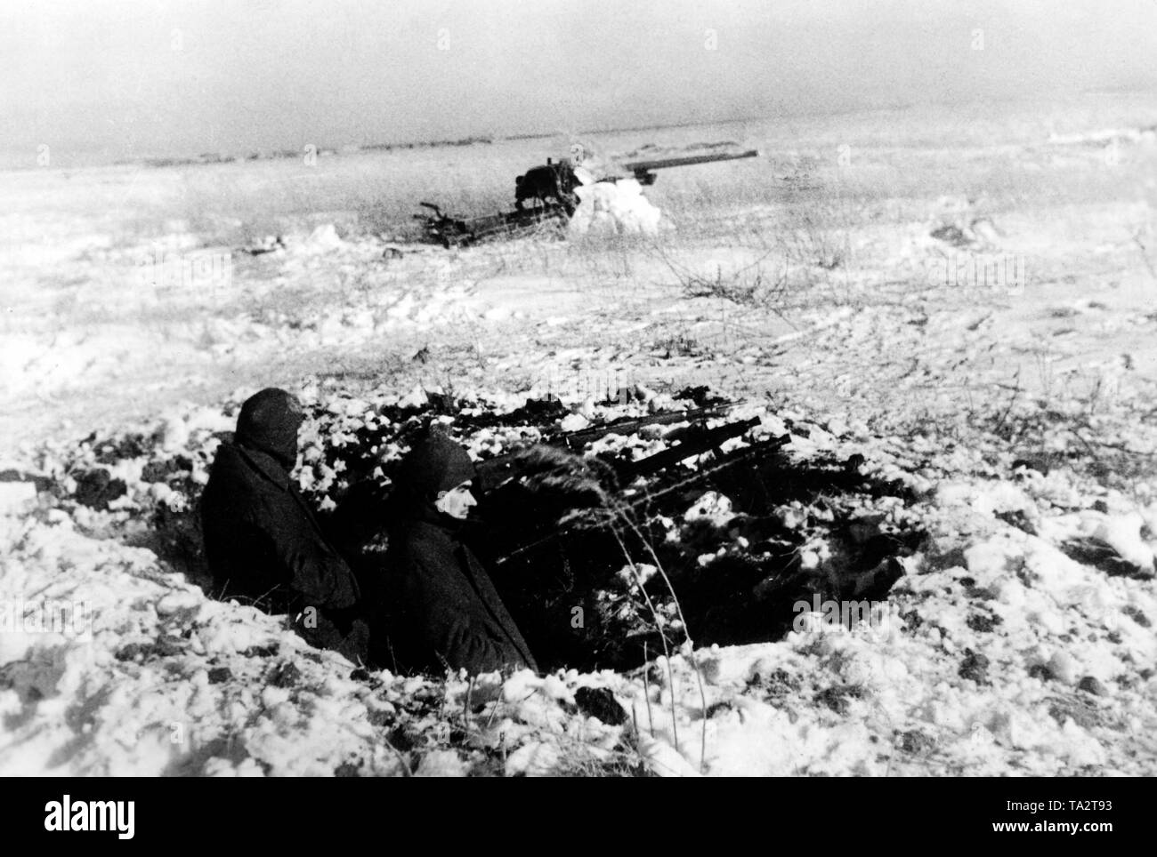 I soldati stanno in un combattimento scavato stand in una posizione in avanti di Mosca nella zona del Gruppo di Armate Centro con MG34 mitragliatrice. In background, un anti-serbatoio cannon. Foto Stock