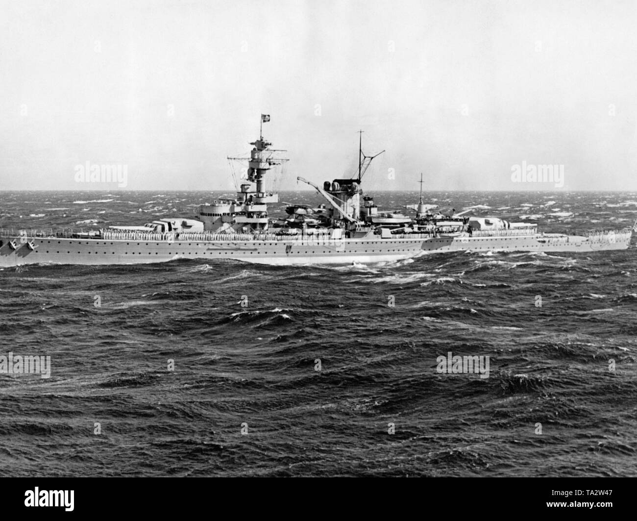 Foto dell'incrociatore pesante 'Deutschland' in un mare tempestoso presi da un fotografo della flotta dell'organizzazione nazista "Kraft durch Freude' ('Sforzo attraverso Gioia") durante una KdF viaggio off la costa italiana il 7 novembre, 1937. L'equipaggio ha schierato sul ponte. A prua e nella parte posteriore sono presenti due torrette con sei 28 cm quick-fire pistole. Al centro di uno dei due velivoli nave del tipo Arado Ar 196. Foto Stock