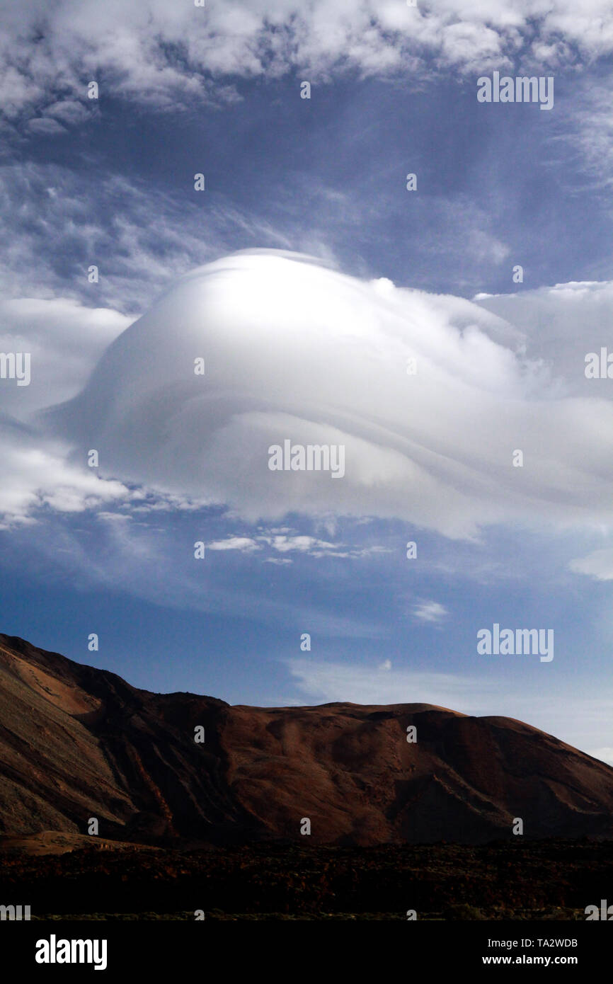 Forma astratta isolato torreggianti dense wave come cumulus cloud oltre il picco di montagna sulle Isole Canarie, Tenerife Foto Stock