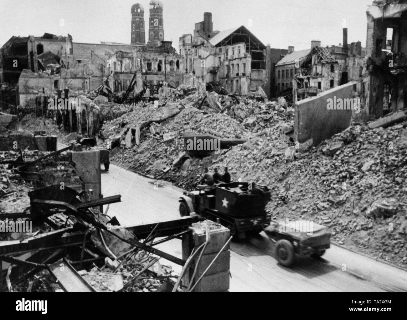 Un americano a mezza via il veicolo del tipo "M15 Semicingolato' rispettivamente 'M15 Combinazione Gun Carrello motore' ride attraverso il Monaco di Baviera Theatinerstrasse. Sullo sfondo le torri della Frauenkirche. Foto Stock