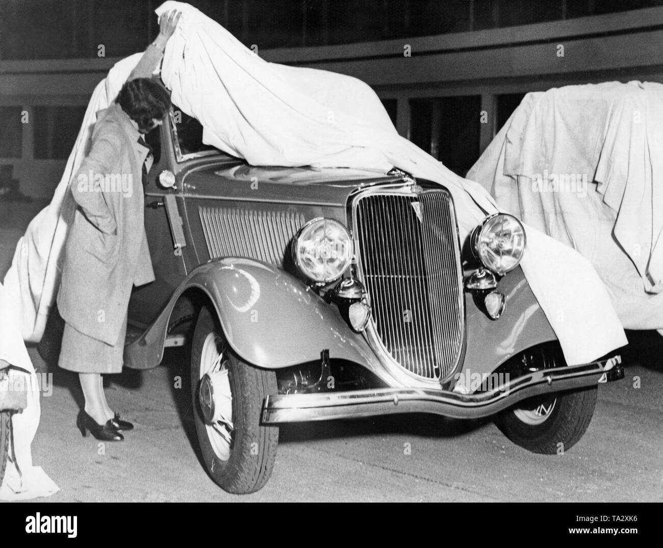 Una donna sta guardando una Ford modello Y poco prima la sua performance presso la Royal Albert Hall di Londra in 1934th Foto Stock