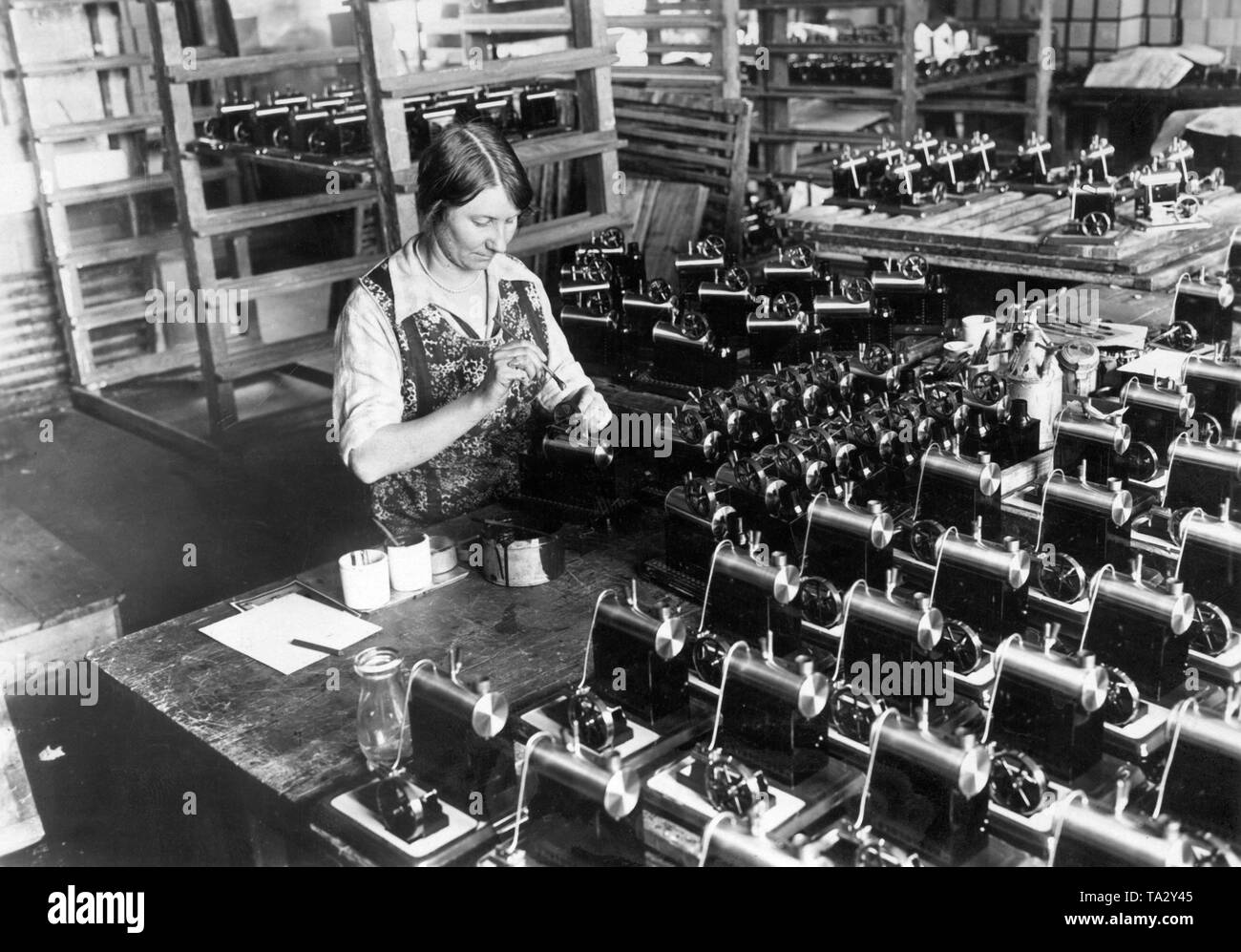 Un lavoratore di sesso femminile che il giocattolo di lubrificazione per motori a vapore in officina di un giocattolo di Norimberga fabbrica. Foto Stock