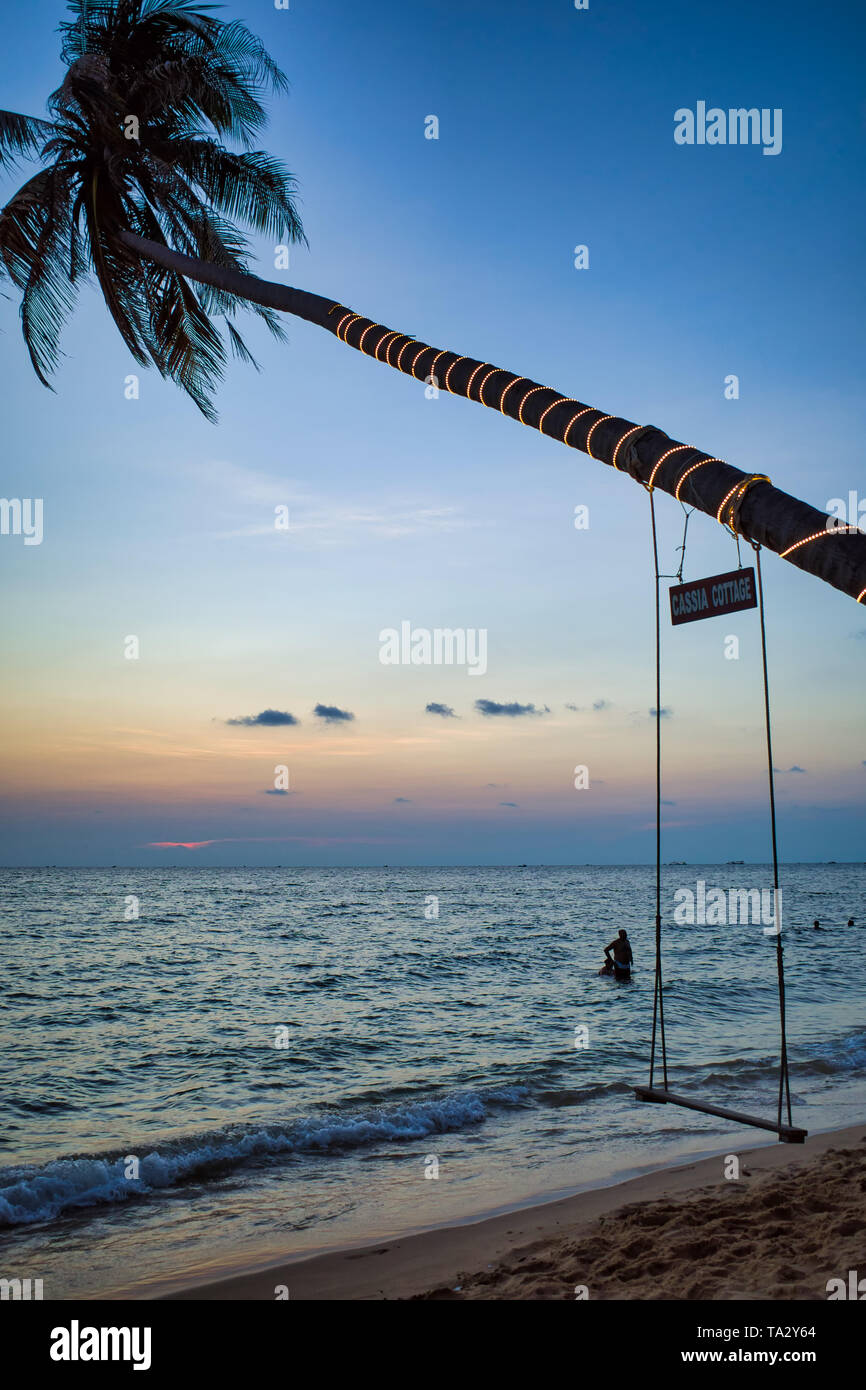 Swing su un albero di palma. Mare spiaggia al tramonto. Spa romanticismo, Phu Quoc island, Vietnam Foto Stock