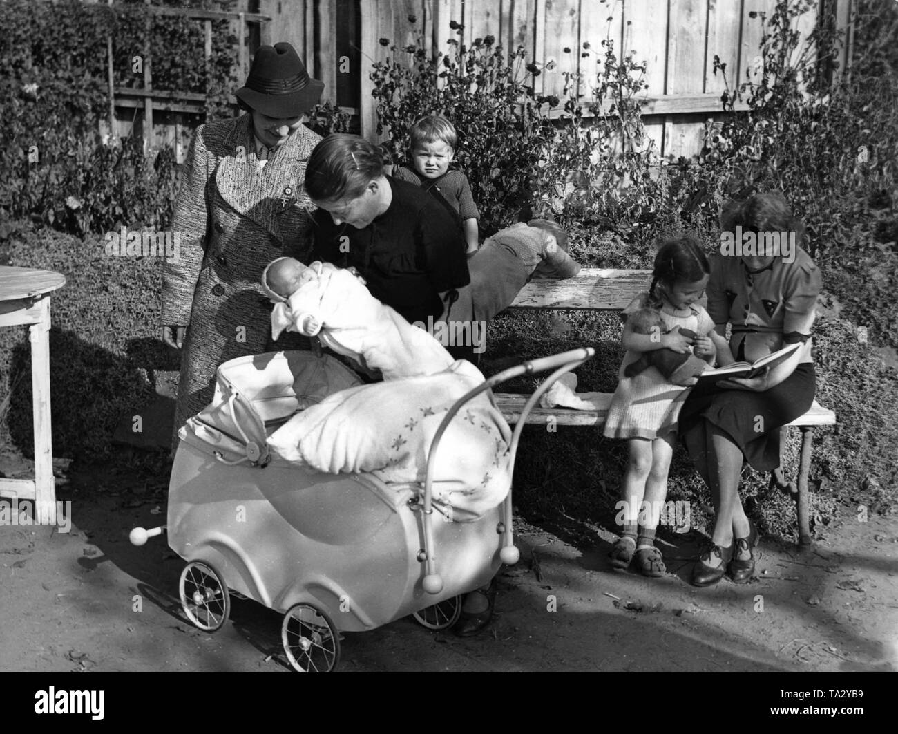 Il leader della NSF Kreisfrauenschaft (femminile di aiuto agenzia) visite evacuato famiglie prima la bomba di guerra. Qui, una madre sta mostrando il suo quinto bambino nato nella Prussia orientale. Foto Stock