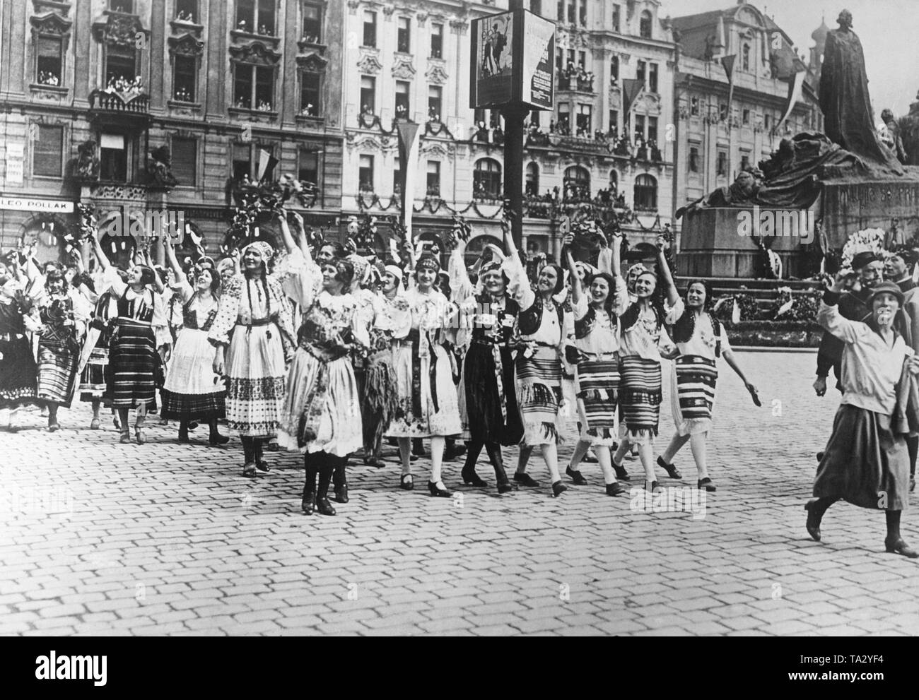 Paese di Moravian ragazze in costumi tradizionali al Sokol congresso a Praga. Le ragazze di salutare il Presidente cecoslovacco Tomas Garrigue Masaryk. Una sfilata avviene in Jan Hus in onore del suo compleanno. Sullo sfondo il Jan Hus Memorial. Foto Stock