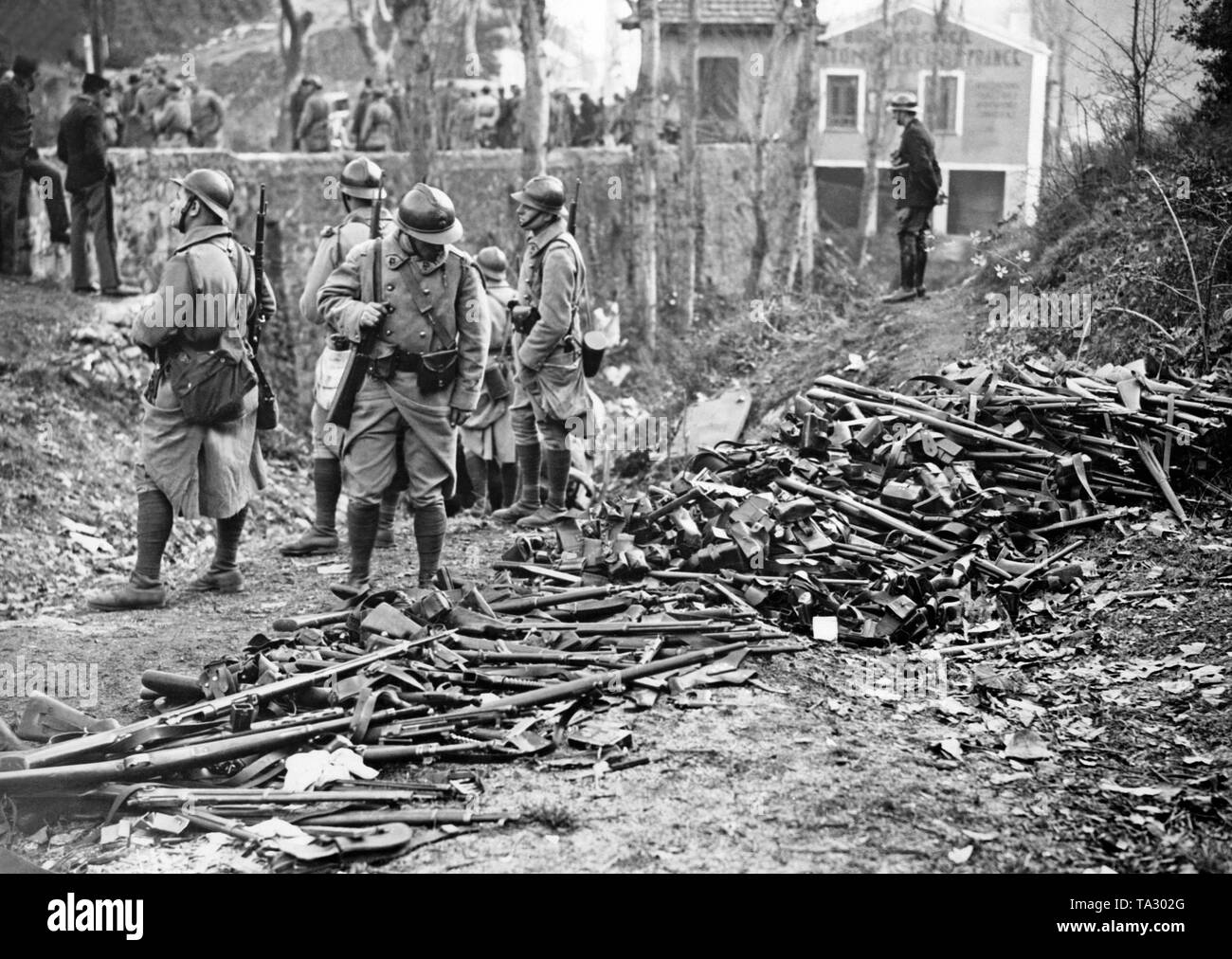 Soldati francesi a esaminare un mucchio di armi che precedentemente era stato lasciato da spagnolo combattenti che erano fuggiti e disarmati alla frontiera. Foto Stock