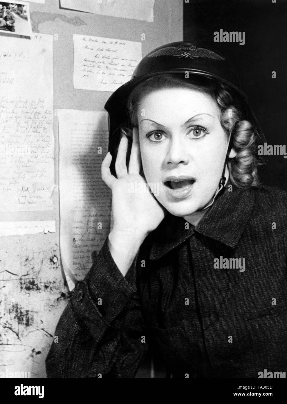 Una ragazza di scala è responsabile per la observence di il corso degli eventi nel corso di un raid aereo nella perforazione della Scala di Berlino. Foto Stock