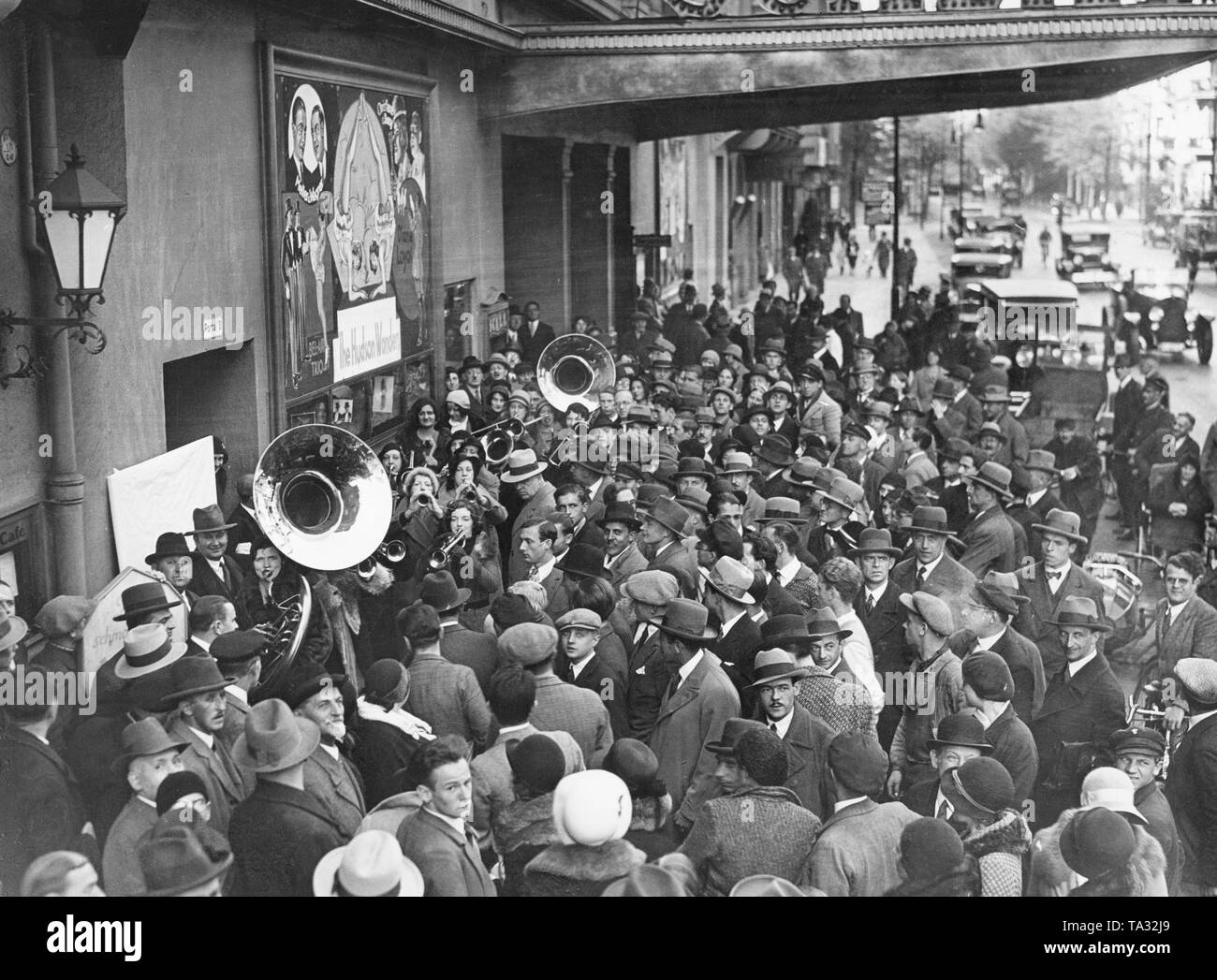 Le persone si radunano davanti alla Scala di Berlino a guardare il 'Musikgirls'. Sul poster mostra di 'Hudson Wonders' che viene pubblicizzato. Immagine non datata, probabilmente dalla fine degli anni venti. Foto Stock