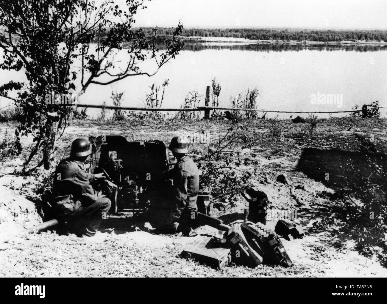 Due tedesche di fanti con un 3rd7 cm-Pak 36, il quale è destinato a coprire fino al fiume attraversando dei pionieri. Foto Stock