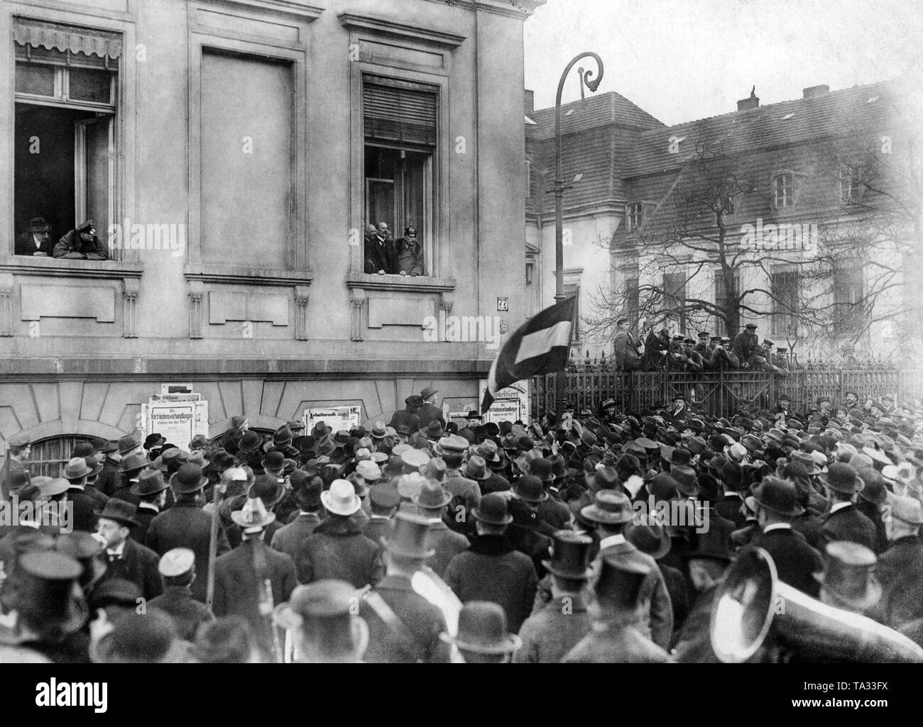 Un rappresentante della nuova Repubblica offre un discorso di fronte a una finestra della Cancelleria del Reich. Una folla è in ascolto di un altoparlante. Foto Stock