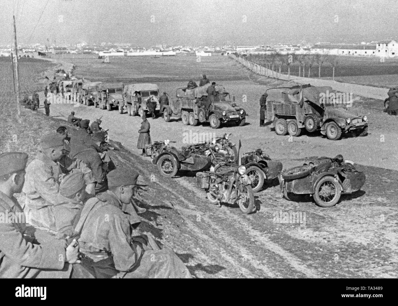 Una batteria antiaerea del tedesco della Legione Condor si appoggiano su una strada a Toledo durante le ultime battaglie della guerra civile spagnola il 28 marzo 1939. Sulla destra in primo piano, Kradschuetze (moto montato fanti) stanno avendo un resto. Le loro motociclette del tipo BMW R12 (parzialmente con sidecar) sono parcheggiate sul ciglio della strada. Dietro, un convoglio di camion del tipo Krupp L2 H143. Foto Stock