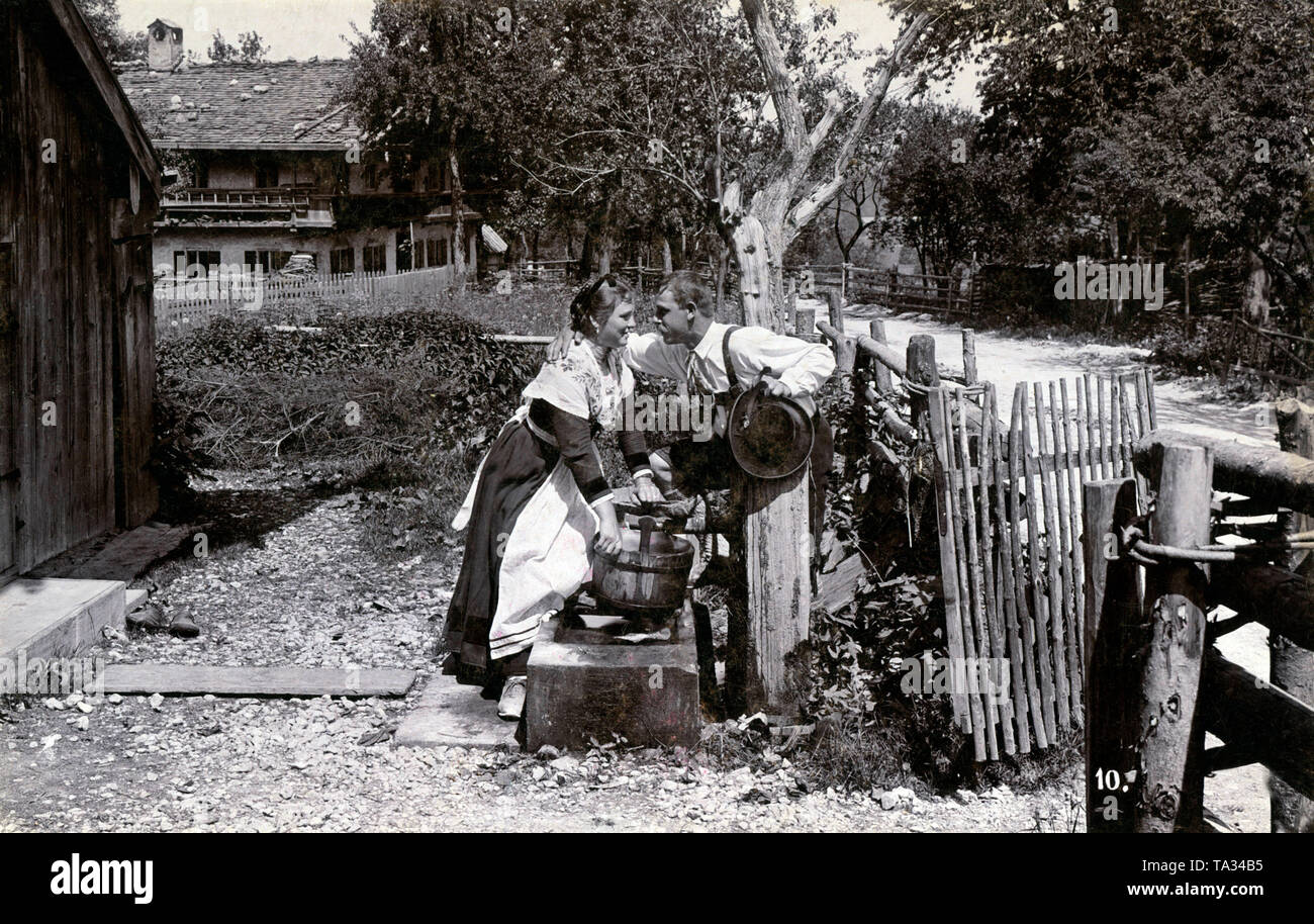 Un giovane in costume mentre il prelievo di acqua nel cortile anteriore. Foto Stock