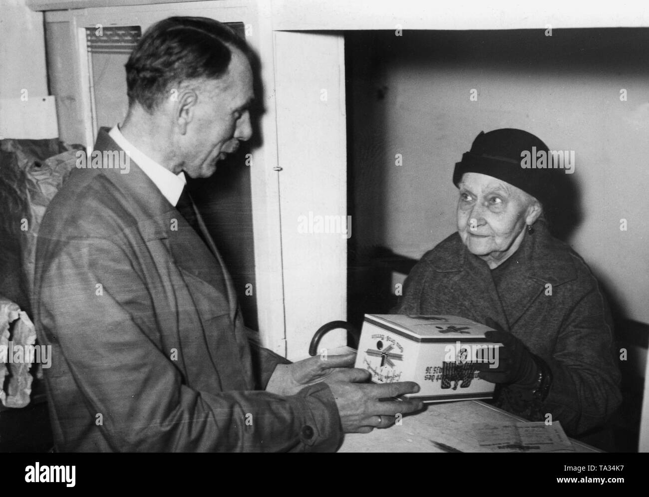 In un ufficio della NS-Volkswohlfahrt, volontari pack natale dei pacchetti per la distribuzione a persone bisognose (nell'immagine, senior citizen) come parte del Winterhilfswerk (sfiato d'inverno). Foto Stock