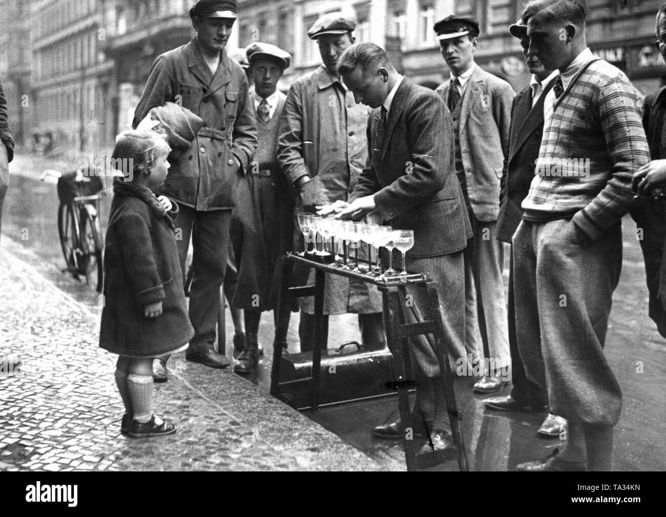 Un disoccupato di musicista di strada gioca sui bicchieri di vino per fare soldi. Foto Stock