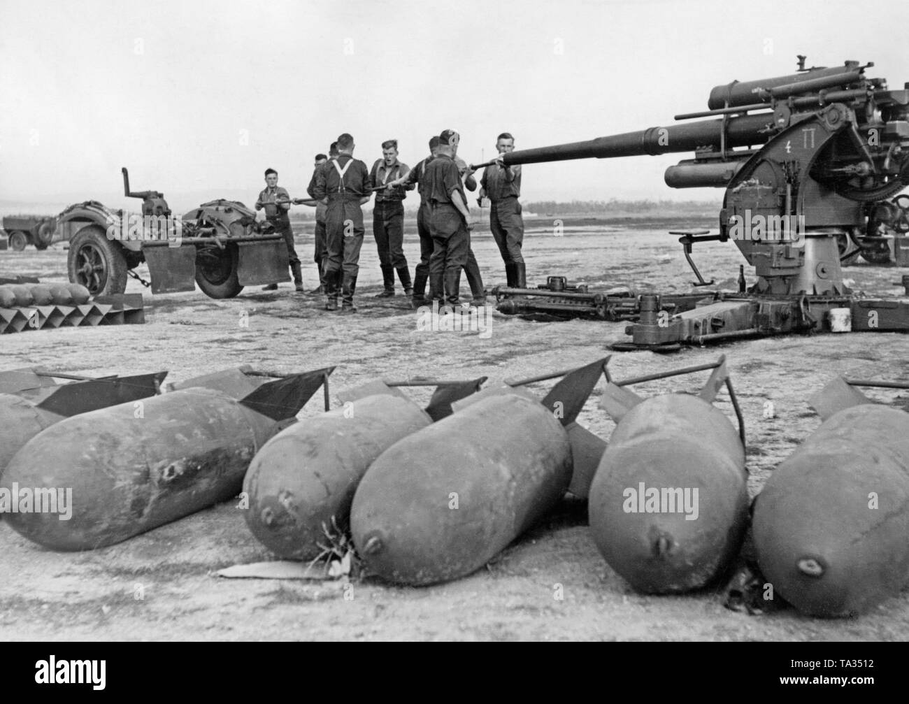 Foto di un gruppo di soldati del Flak corps 88 della Legione Condor pulizia di un Flak 8,8 cm 18/36/37 su un aeroporto in Spagna, 1939. I soldati sono la pulizia della canna del cannone. Di fronte vi sono 250kg bombe aeree. Foto Stock