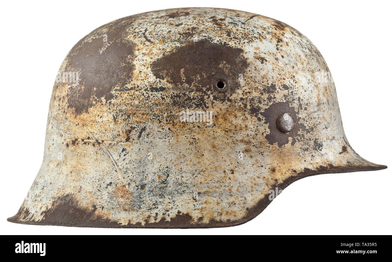 Un casco in acciaio M 40 per i membri dell'esercito o Waffen-SS in inverno camouflage cranio in acciaio (ruggine) con bianco vernice camouflage sopra il campo-grigio dello strato di base. Rivestimento interno e mancanti di cinghia per il mento. storica, storica, esercito, eserciti, forze armate, militare, militaria, oggetto, oggetti, alambicchi, clipping, clippings, tagliate, cut-out, ritagli del xx secolo, Editorial-Use-solo Foto Stock