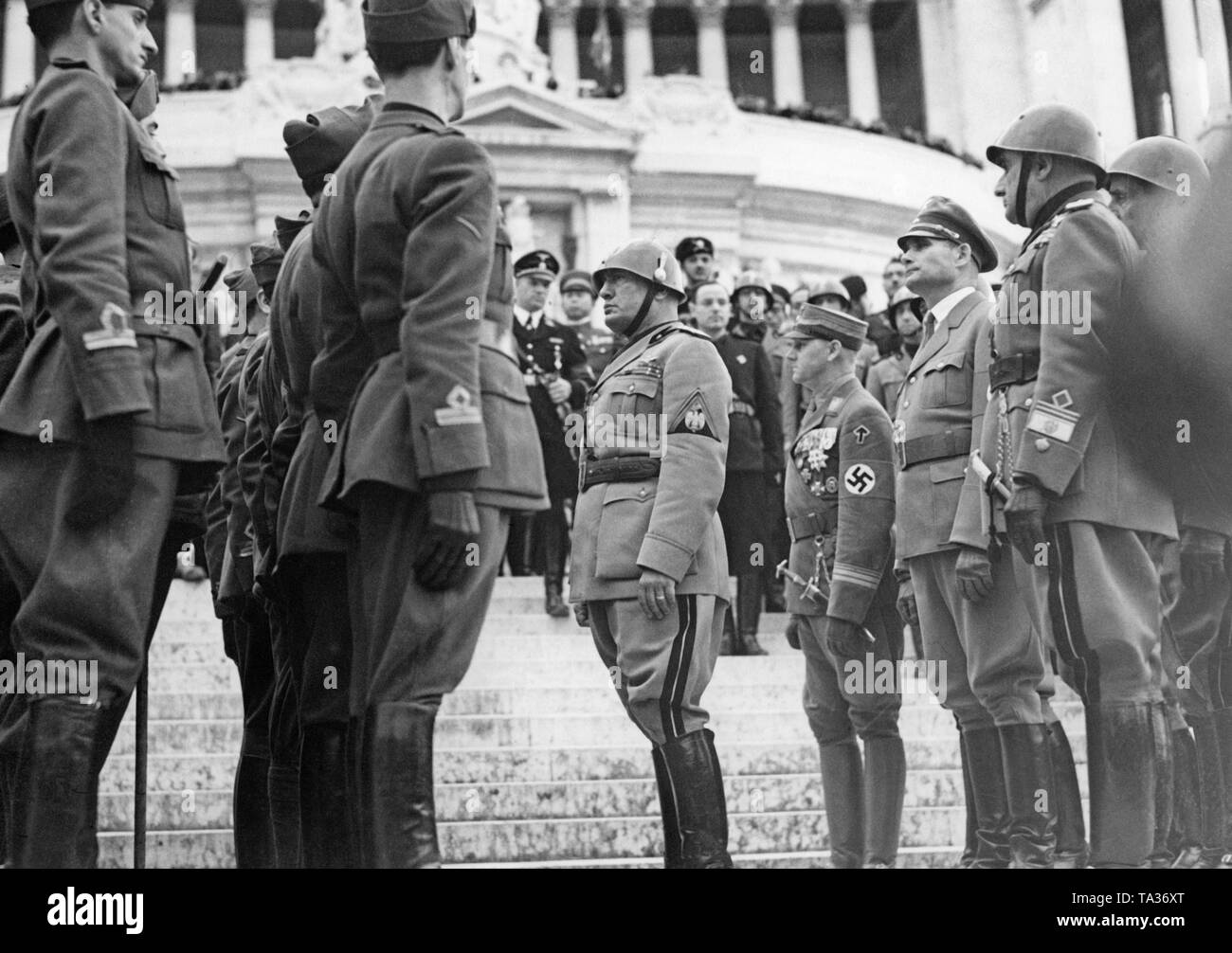 Nella parte anteriore del 'Altare della Patria" (Monumento Nazionale a Vittorio Emanuele II) il Duce Benito Mussolini (centro, con acciaio casco), membri della milizia fascista e gli ospiti stranieri commemorare i caduti legionari italiani della Guerra Civile Spagnola a Roma il 31 ottobre. Dietro il Duce da sinistra a destra: Viktor Lutze ( Capo del personale della SA) e il ministro del Reich Rudolf Hess. Foto Stock