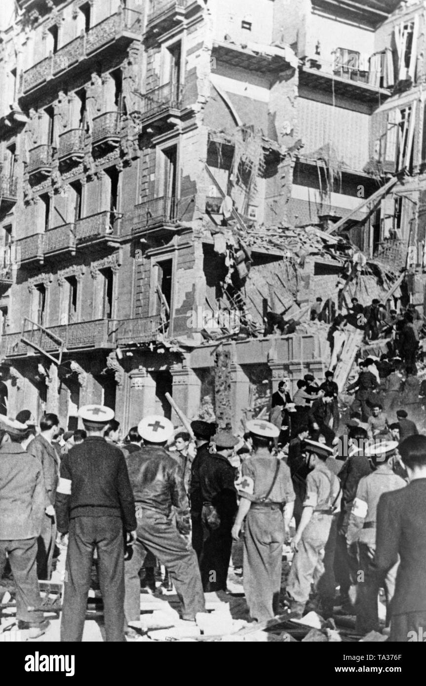 Foto di un parzialmente distrutti sette piani casa a la Plaza de Catalunya di Barcellona dopo un attentato alla bomba da la nazionale spagnola Air Force il 19 marzo 1938. Civili e paramedici tentare di recuperare i superstiti dalle macerie. Foto Stock