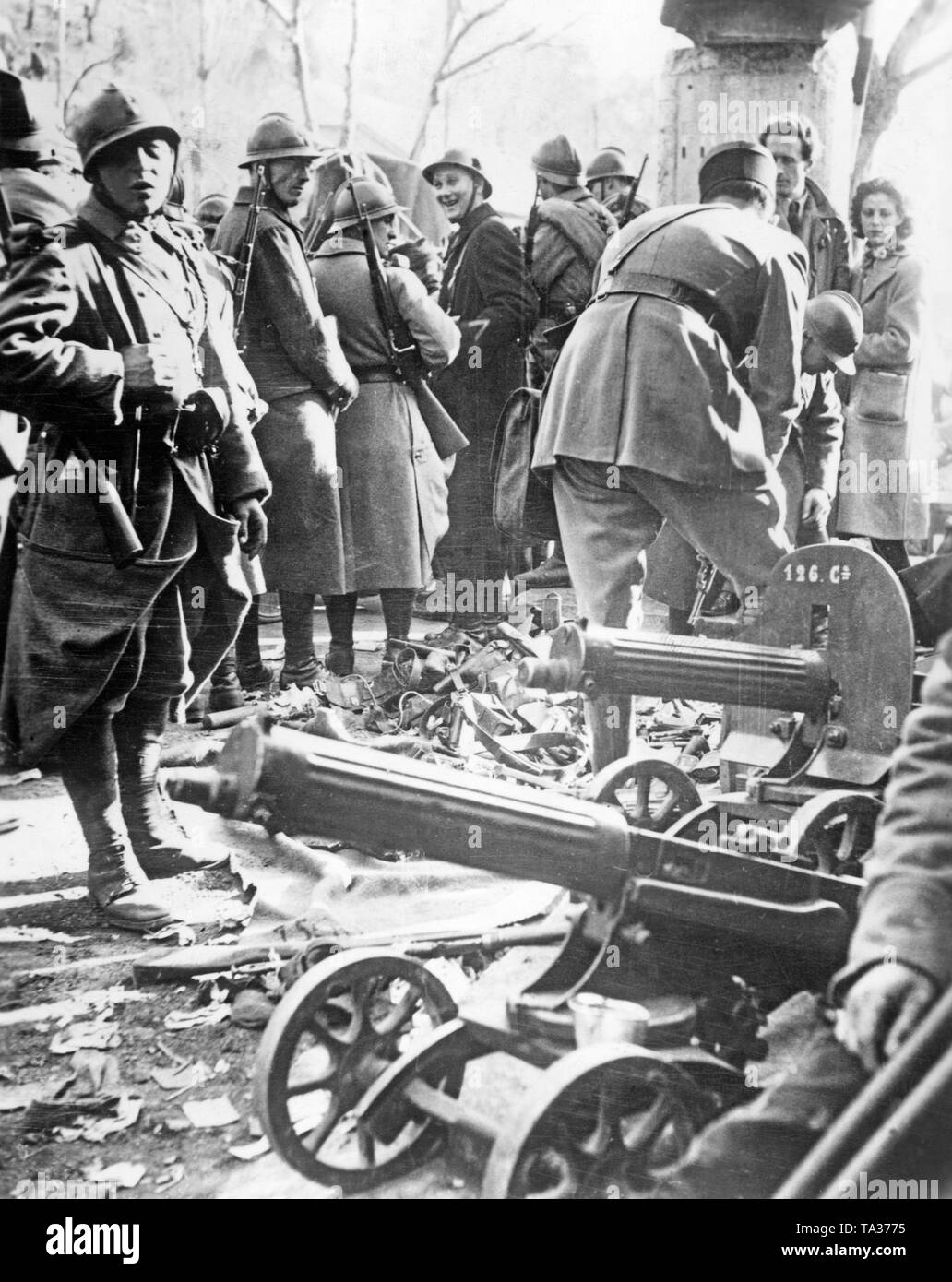 Soldati francesi e dei civili di ispezionare una collezione di consegnare le pistole della Repubblica combattenti che sono fuggiti in Francia. In primo piano sono due Maxim pistole di macchina di progettazione sovietica. Foto Stock