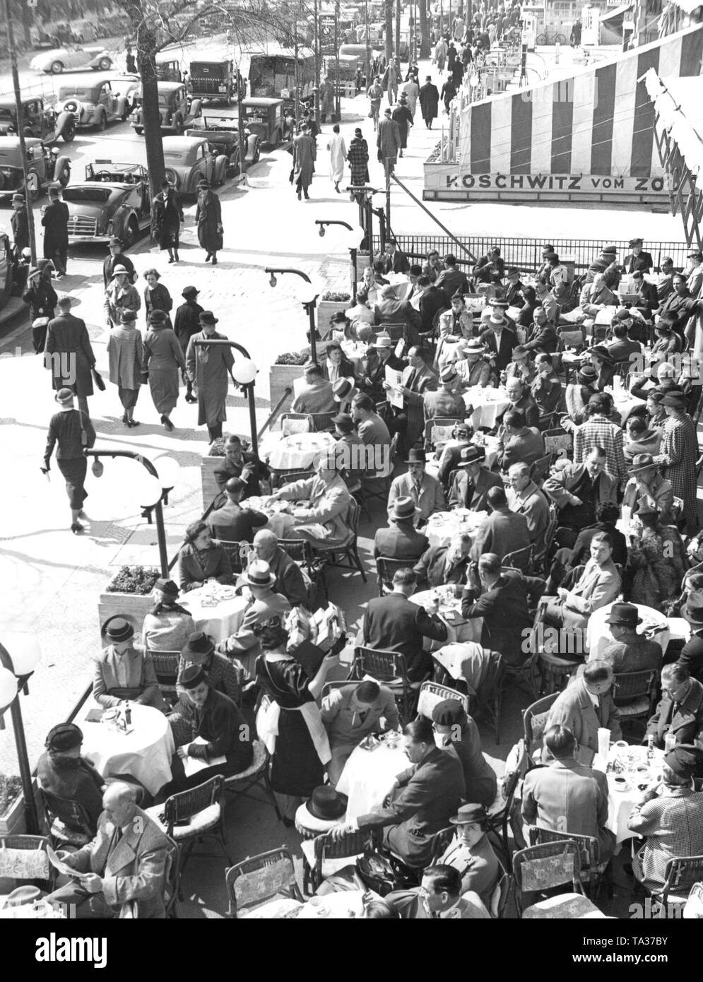 Il primo Café Kranzler a Berlino è stato aperto nel 1825 da Johann Georg Kranzler come una piccola pasticceria in strada "Unter den Linden" nel distretto Mitte di Berlino. Nel 1932 aprì il secondo ramo dell'ex Café des Westens sotto il nome di 'Restaurant und Konditorei Kranzler' in la Joachimstaler Strasse (oggi Joachimsthaler Strasse) nel quartiere Charlottenburg. Entrambi gli edifici sono stati distrutti durante i raid aerei negli anni 1944 e 1945. La foto mostra la strada terrazza, il cosiddetto "rampe", con alcuni ospiti. Foto Stock