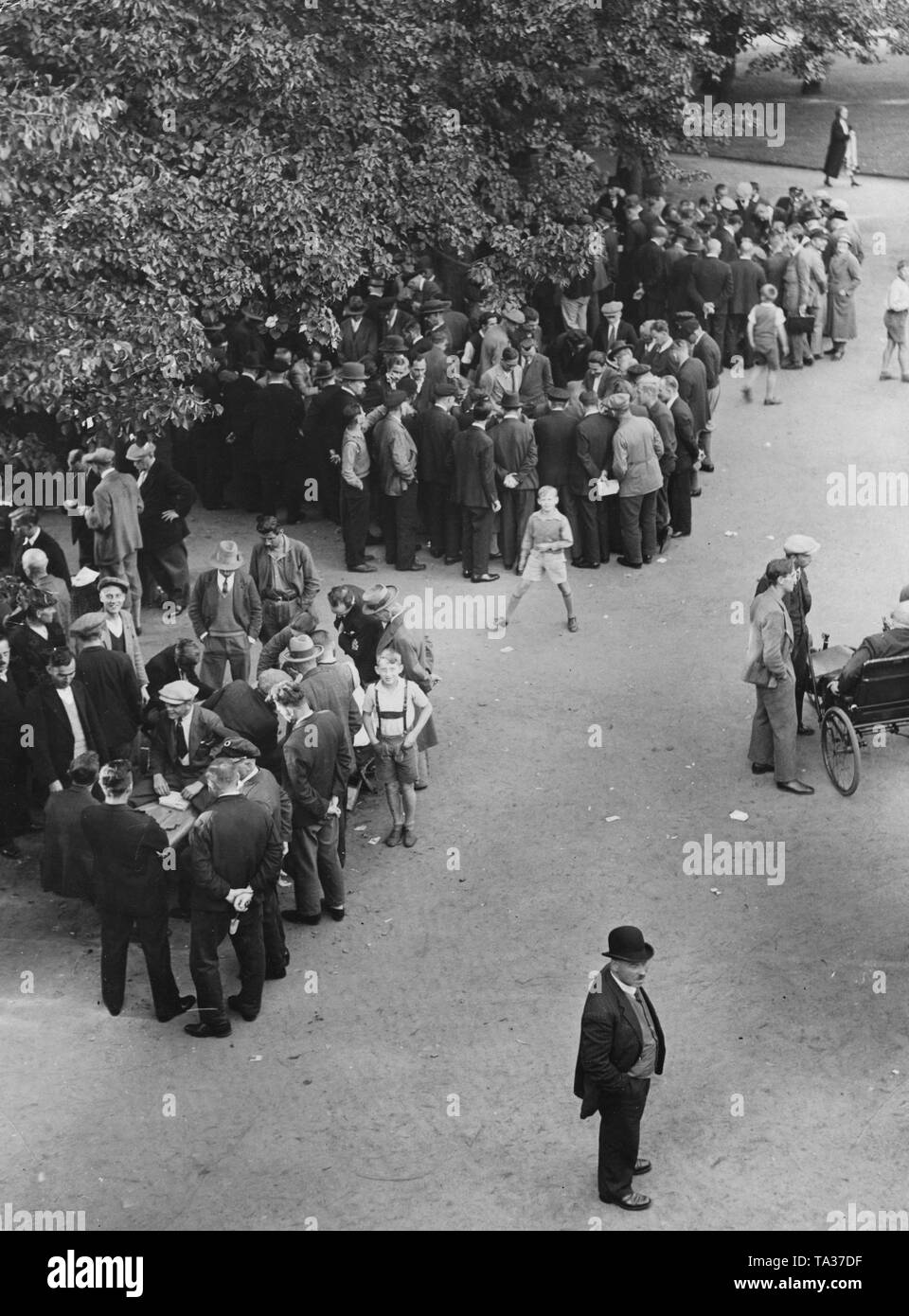 Gruppi di ruote folli in un parco di Berlino di giocare a carte o guardare gli altri. Il numero di disoccupati, era diminuita come risultato dei programmi per la creazione di posti di lavoro del regime Nazional Socialista, ma rimaneva ancora alta. Foto Stock