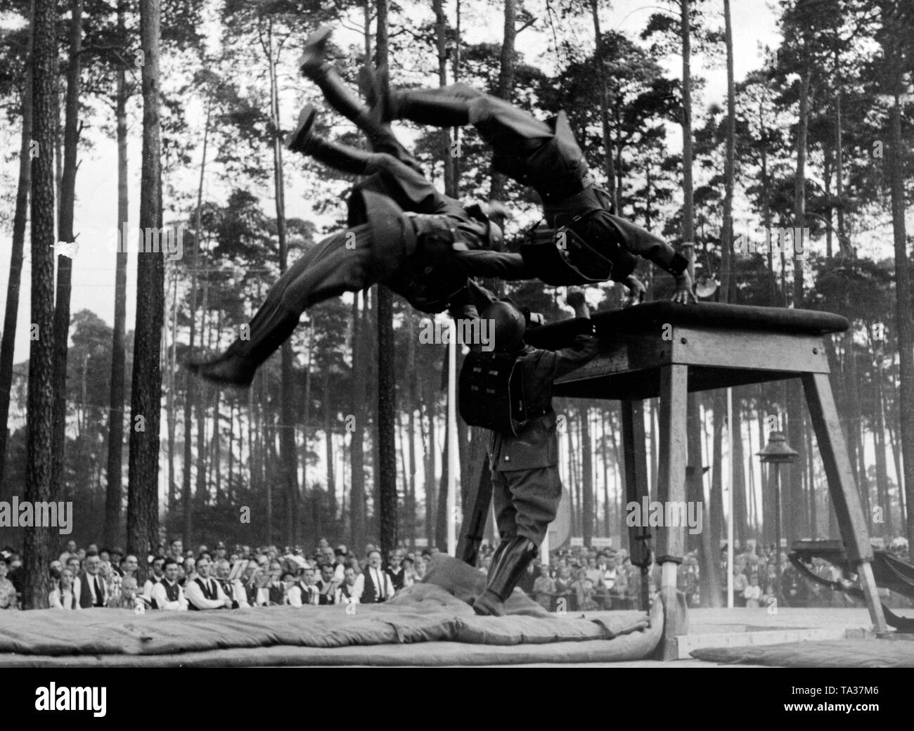 Nella città stabilita dell'organizzazione nazista "Kraft durch Freude' ('Sforzo attraverso Gioia") a Valznerweiher, funzionari in uniforme della Schutzpolizei da Berlino fare esercizi di ginnastica sul trampolino di fronte agli spettatori durante il Rally di Norimberga del NSDAP. Foto Stock