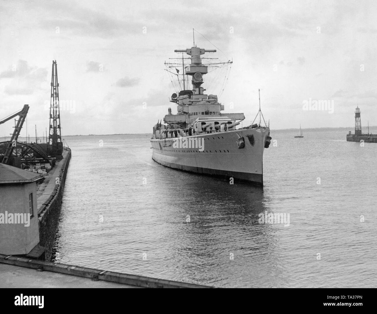 Foto del distrutto parzialmente incrociatore pesante 'Deutschland' quando entrando nel porto di Wilhelmshaven sul Mare del Nord nel giugno 1937. A destra e a sinistra, le strutture portuali. Foto Stock