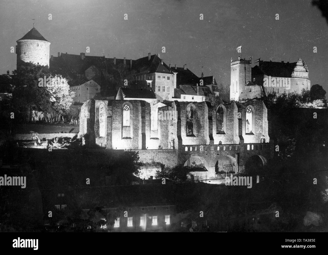 Vista la rovina illuminata della Santa Chiesa di San Nicola, costruita nel XV secolo e distrutta nel 1620, a Bautzen, in Sassonia. Sullo sfondo sono le mura e le torri di Ortenburg. La foto è stata realizzata in occasione del millesimo anniversario di Ortenburg, che è stato menzionato per la prima volta nel 928. Foto Stock