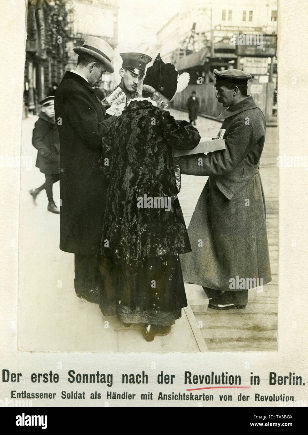 Due soldati scaricato in una strada di Berlino la vendita di cartoline con le foto della rivoluzione. Foto Stock