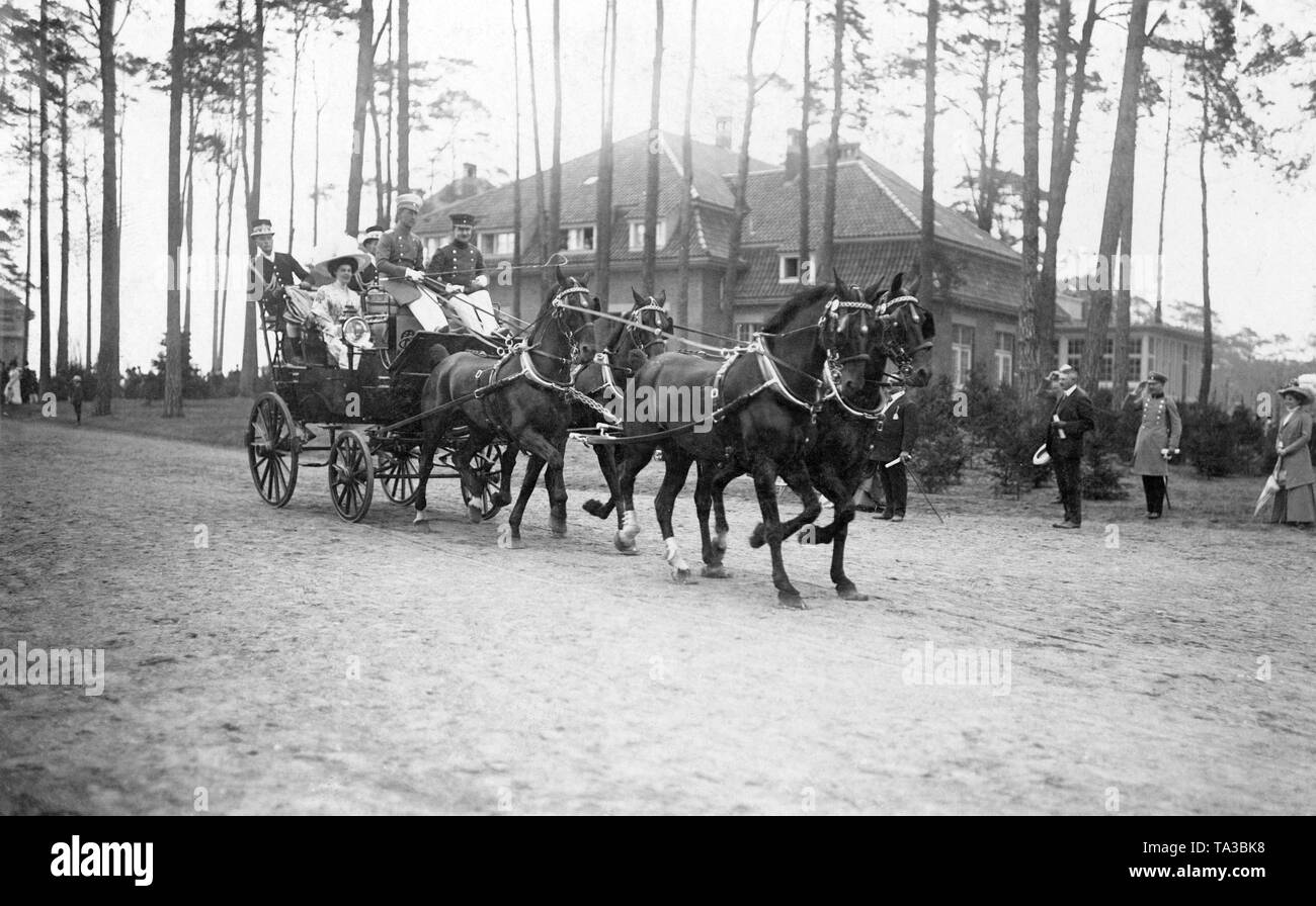Il Principe e la principessa rigido per la gara di apertura con un quattro-in-trasporto a mano. Nella parte anteriore della scatola di pullman sit principe ereditario Wilhelm (l) e suo fratello August Wilhelm (r). Nella parte posteriore della vettura sono le due mogli Crown Princess Cecilie (sinistra), nato Duchessa di Mecklenburg e la Principessa Alexandra Viktoria (a destra), nato Duchessa di Schleswig-Holstein-Sonderburg-Gluecksburg. Foto Stock