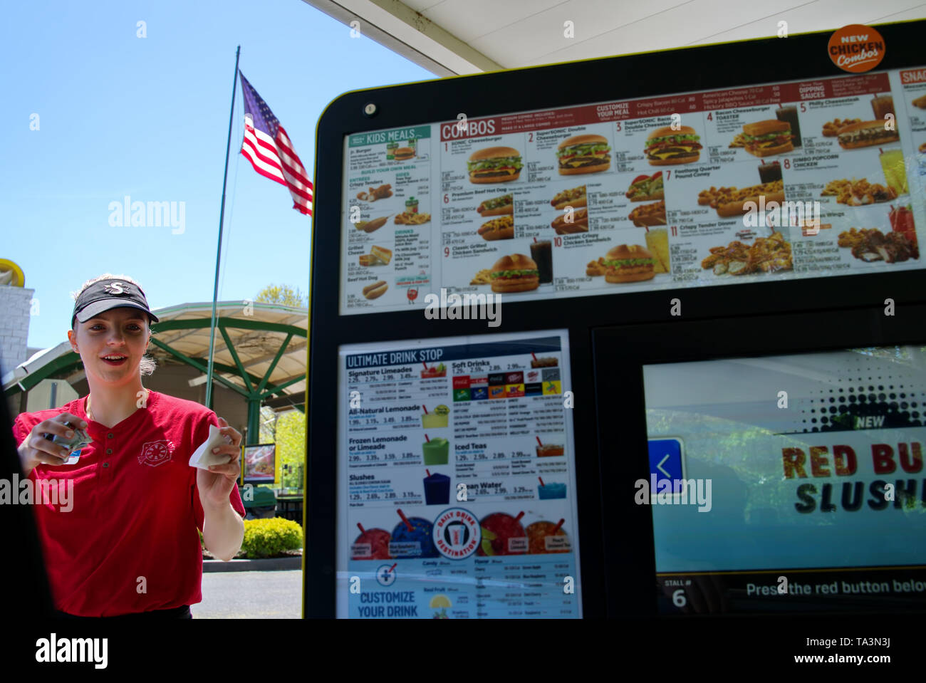 Wallingford, CT, Stati Uniti d'America. Maggio 2019. Un Sonic fast food giovani donne carhop serve rapidamente condimenti per i clienti in auto al drive-in. Foto Stock