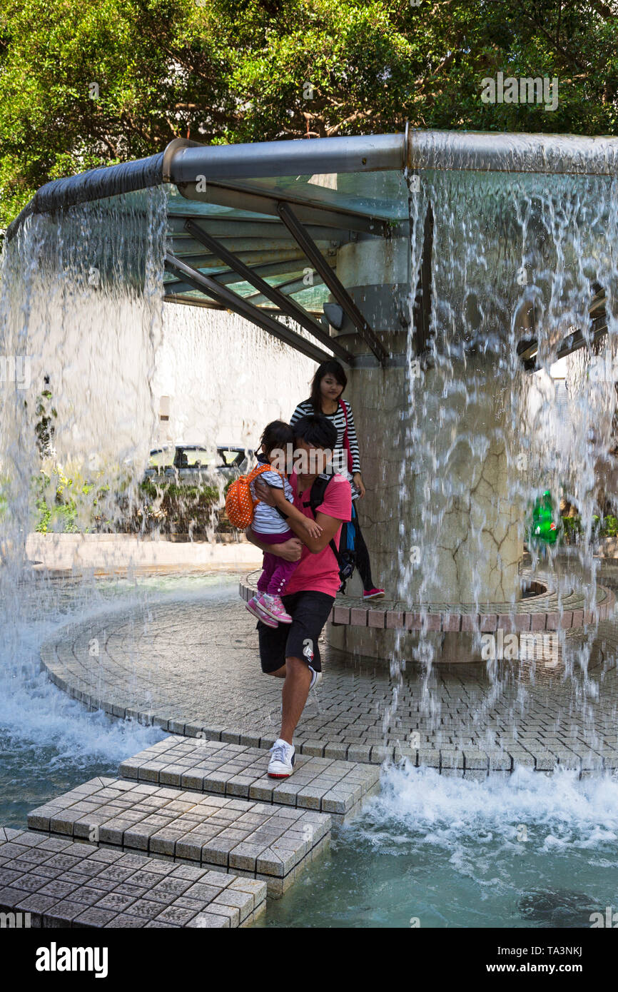 Bambini che giocano nella fontana di Hong Kong Park, SAR, Cina Foto Stock