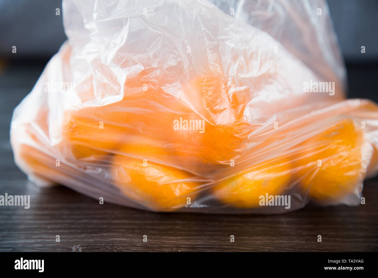 Mandarini acquistati al supermercato in un singolo uso di produrre una busta di plastica. Non rispettosi dell'ambiente. Bella la frutta di arancia, nessun marchio che mostra. Foto Stock