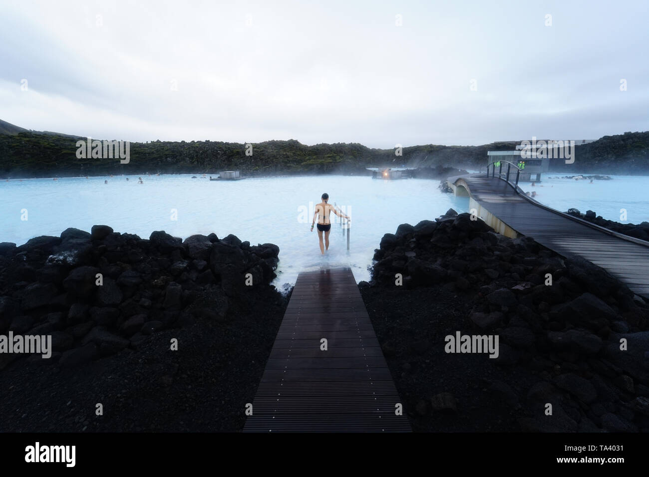 Una donna entra nella piscine geotermiche in Islanda della laguna blu Foto Stock