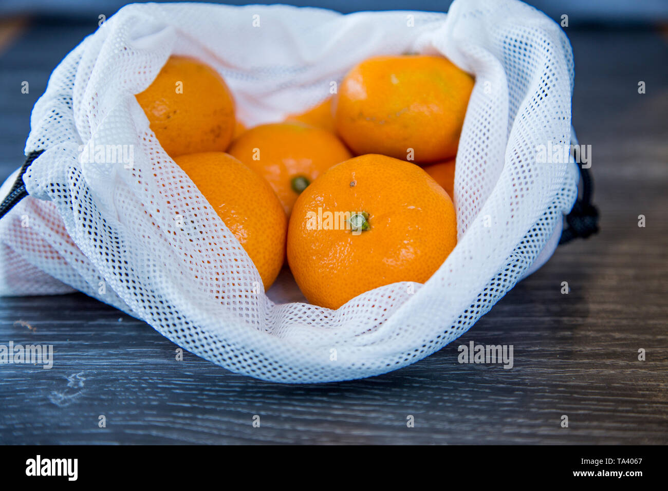 Mandarini acquistati al supermercato in un riutilizzabili per produrre borsa riutilizzato da uso singola soft di sacchetti di plastica. Rispettosi dell'ambiente scelta. Foto Stock