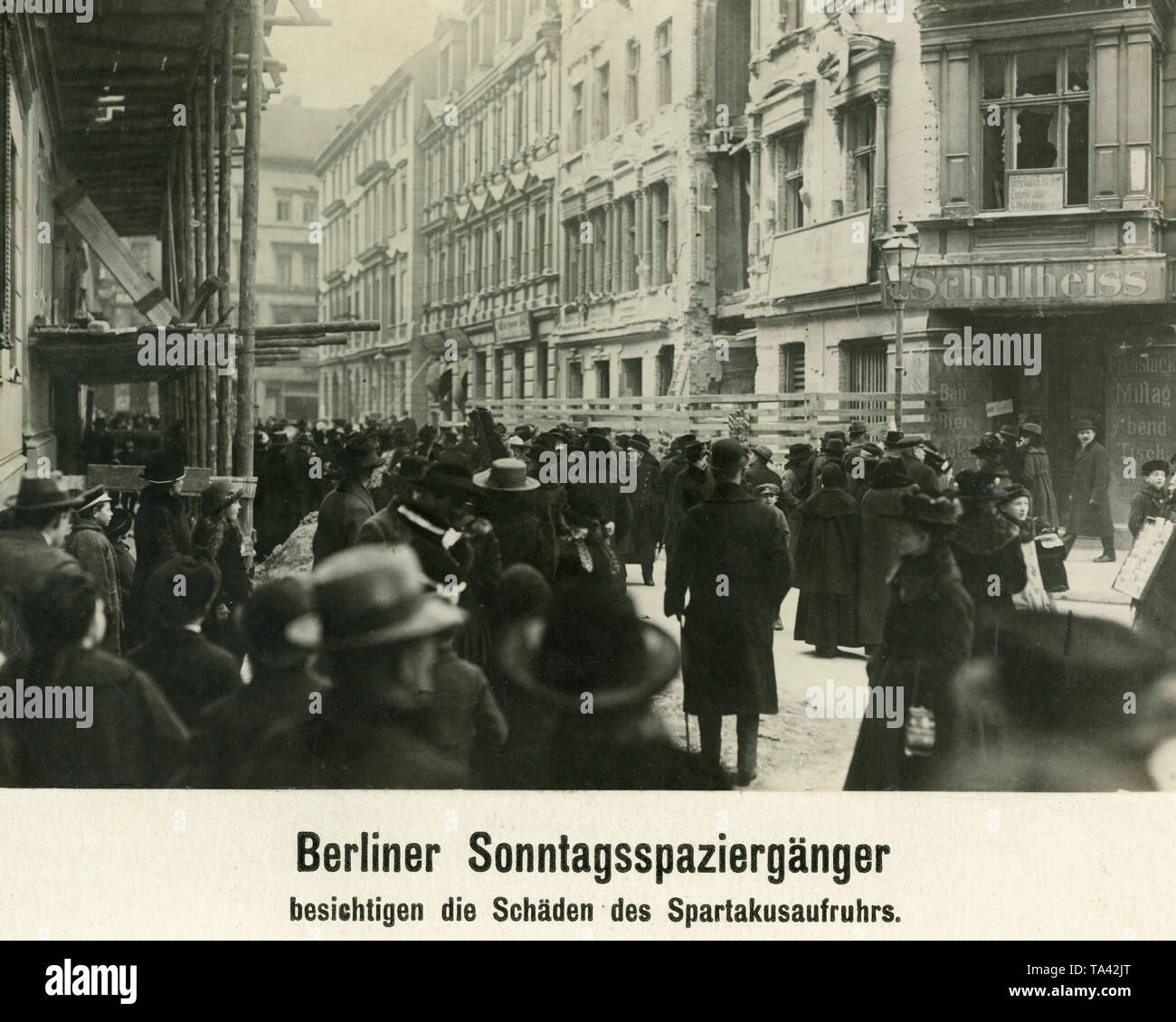 I cittadini e i soldati scarica guardare le distruzioni delle case in una strada di Berlino. Sulla destra si trova un bar dove Schultheiss birra servita. Foto Stock