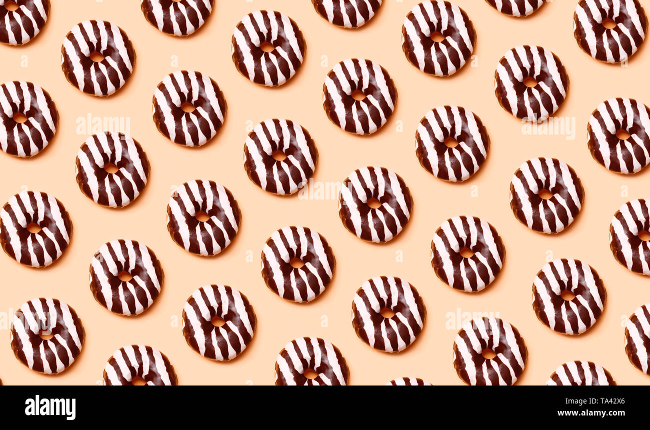 Ciambelle al cioccolato pattern su sfondo arancione Foto Stock