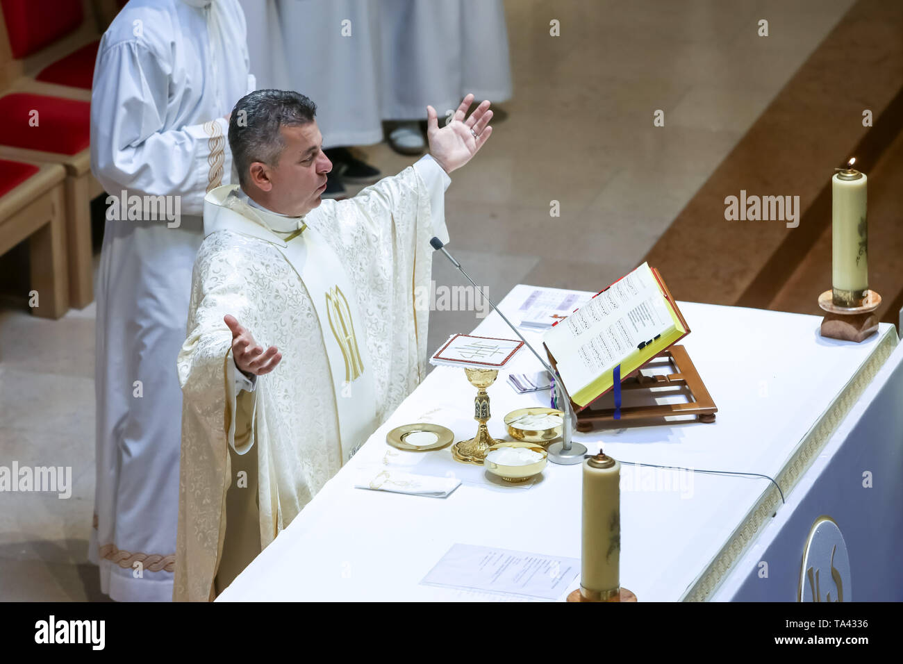 Sacerdote cattolico durante la prima comunione immagini e fotografie