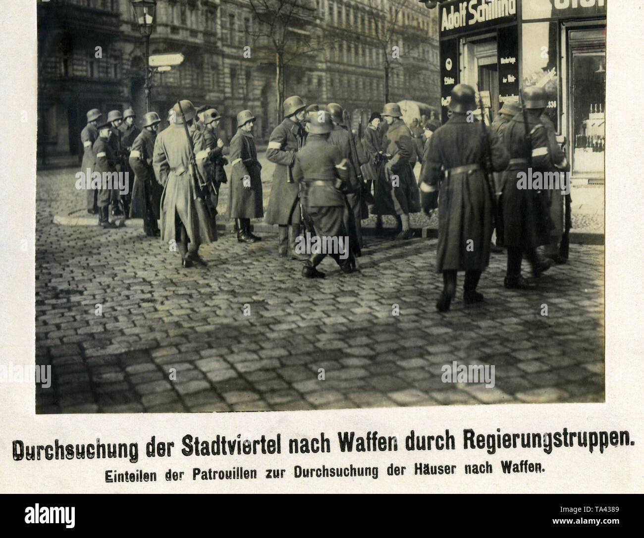 Governo lealisti sono suddivisi in gruppi di ricerca le case adiacenti per armi. Le truppe appartengono probabilmente al Freikorps Reinhard. Foto Stock