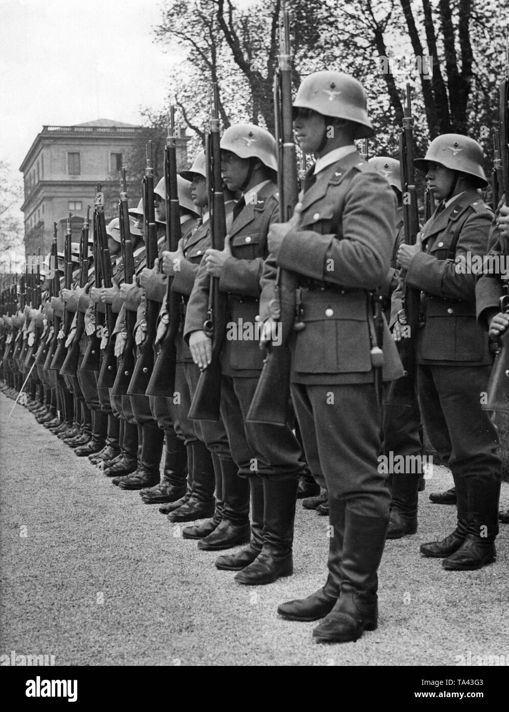 Un allineati azienda della Luftwaffe alla presentazione dei bracci. Il soldato nel centro è dotato di un cosiddetto "tahlhelm mit Ohrenausschnitten', noto anche come "casco di cavalleria". Le diverse apparecchiature suggerisce che la foto è stata scattata nei primi anni della Luftwaffe. Foto Stock