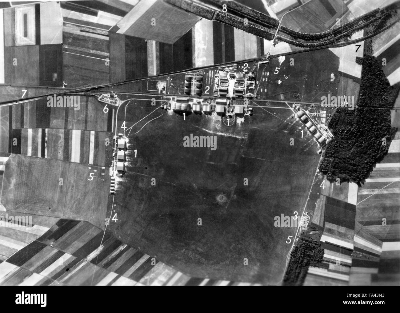 Foto del Reims - Champagne Air Base, prese da long-range ricognitori della Luftwaffe. I punti numerati indicano gli obiettivi militari della Luftwaffe. (1) i marchi hangar moderno, per cui un Luftpark (base di supporto (2) è affiliata. Sotto a destra presso la zona di manovra, un grande deposito di munizioni. Numero (4) indica la presenza di diversi cannoni contraerei. Numero (5) sta per un cosiddetto trincee di copertura contro la bomba splinter. In aggiunta, un ricaricamento di un punto che era stato istituito per le bombe e munizioni (6) lungo il Reims-Laon strada di accesso (7). Nel bordo superiore della foto, la zona intorno al Foto Stock