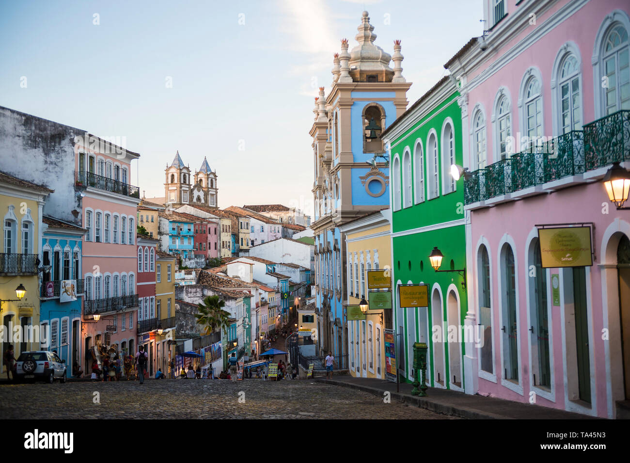 SALVADOR, Brasile - Marzo 2018: le luci di strada dot la colorata architettura coloniale come la notte scende sulle colline di ciottoli di Pelourinho. Foto Stock