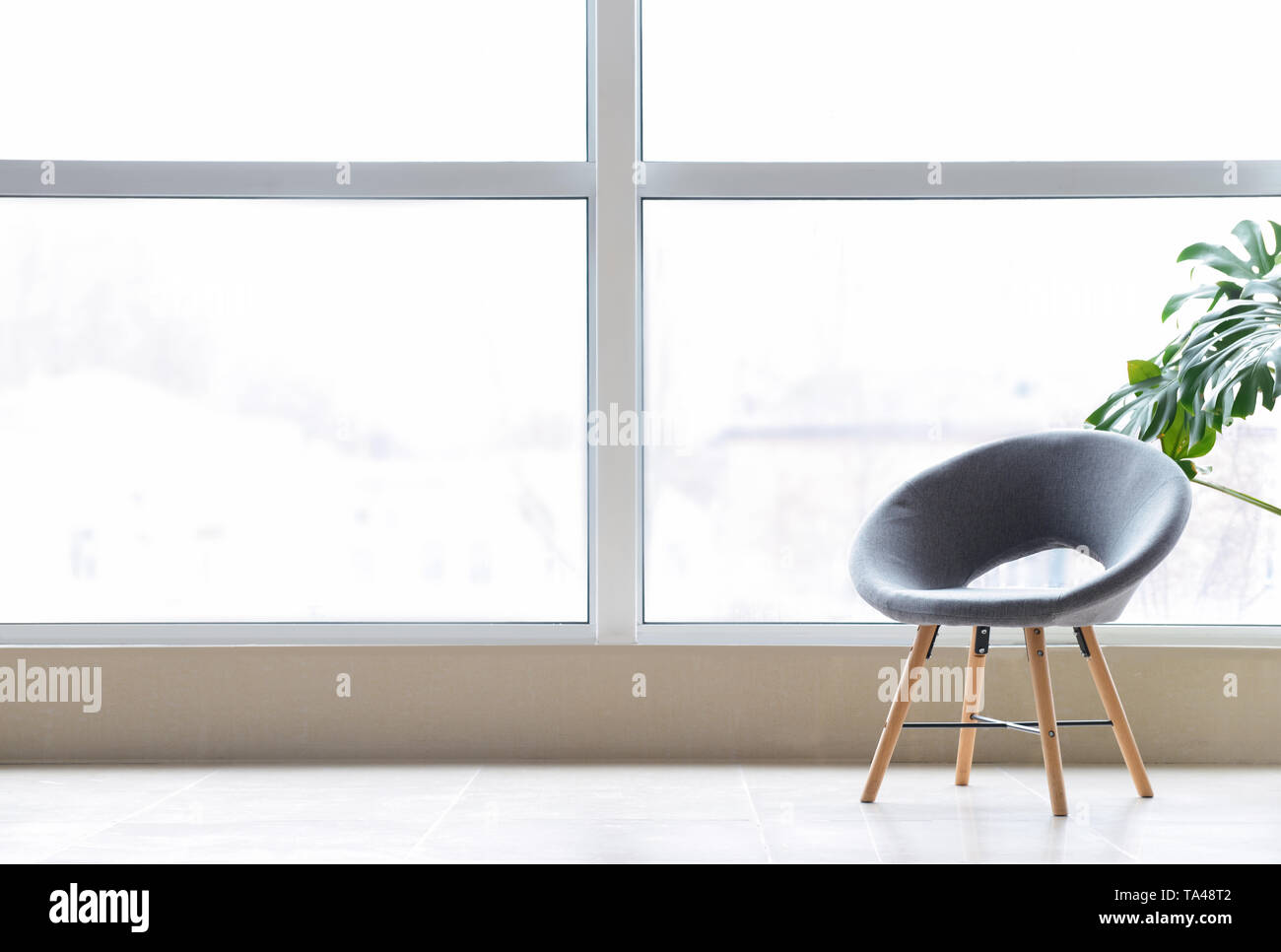 Elegante sedia vicino al grande finestra in camera Foto Stock