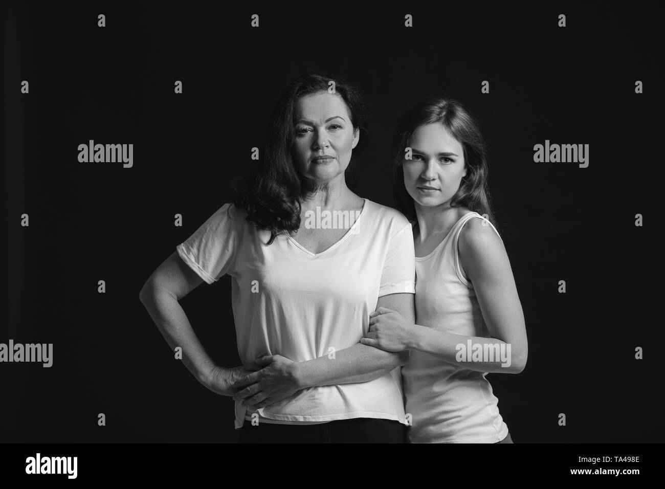 Bianco e nero ritratto di giovane donna con sua madre su sfondo scuro Foto Stock