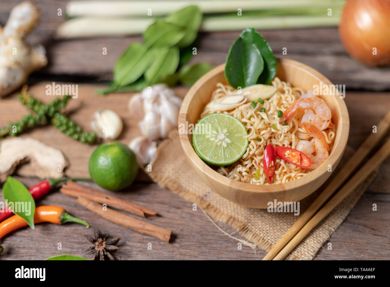 Close-up shot spaghetti istantanei con limone gamberi peperoncino piccante e speziato sul vecchio tavolo in legno selezionare focus leggera profondità di campo Foto Stock