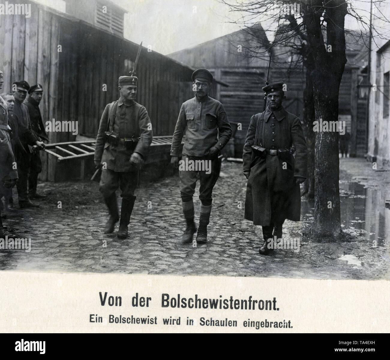 Un bolscevico catturato viene portato via da due soldati tedeschi di una unità dei Freikorps in Lituania Schaulen. Il soldato a sinistra indossa un teschio insegne sul campo cap, creduto per essere il monogramma del Freikorps " Ferro divisione". Foto Stock
