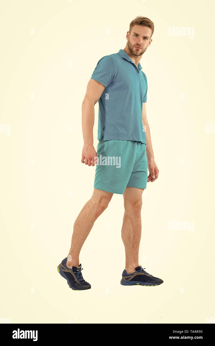 Macho indossare vestiti per uno stile di vita attivo allenamento o  addestramento. Uomo abiti sportivi isolati su sfondo bianco. Uomo Barbuto  in blu abiti casual. Sport stile di moda e di tendenza.